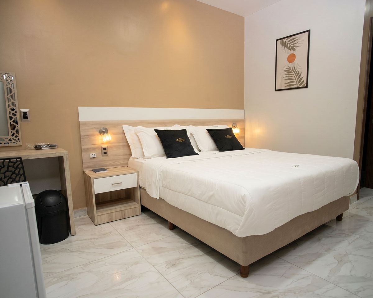 Individual room with a large bed at Los Olivos Hotel